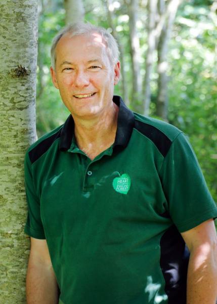 Ian Lockren, our Assistance Tree Nursery Manager, leaning against a tree wearing his Forest uniform