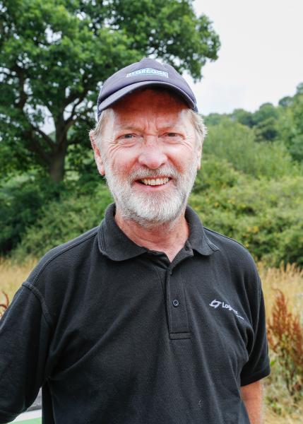 Mike Hudson, Volunteer Leader wearing a cap smiling at the camera