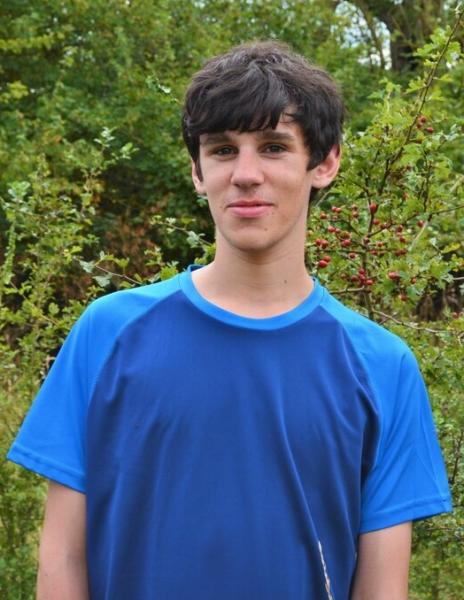 Head and shoulders shot of Harry wearing a blue t-shirt standing in the Forest