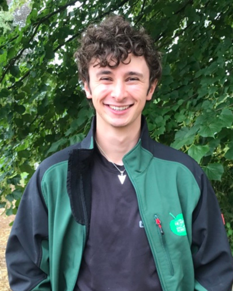 Zachary stood smiling in front of a lime tree