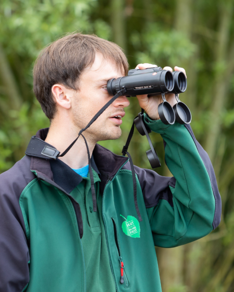 Sam looking through a pair of binoculars