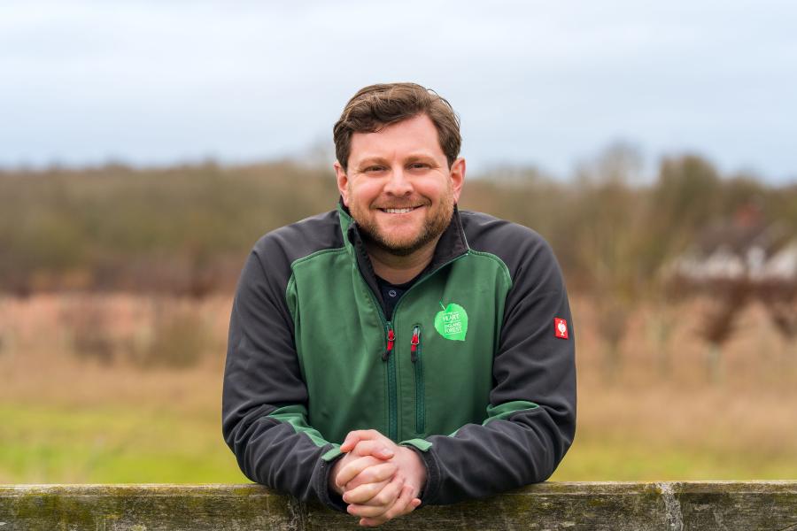 Nick Simms leaning on a fence, smiling at the camera 