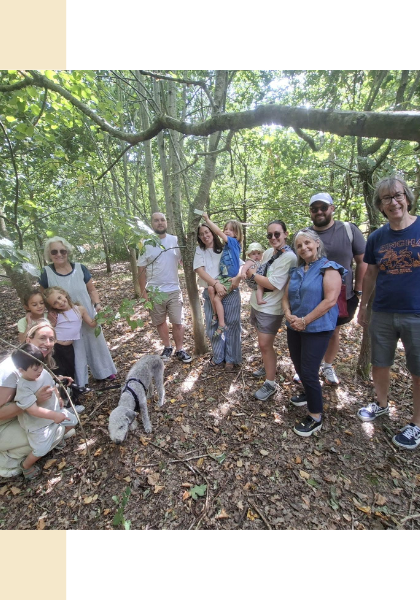 Leonie's family all smiling together in front of their tagged tree.