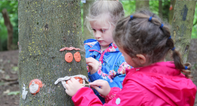 A couple of children being creative in the woodland at Middle Spernal