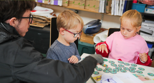 A couple of children doing crafts with a member of staff at Middle Spernal