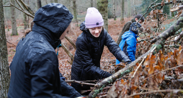 A group of Young Foresters cutting tree branches together at Middle Spernal