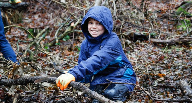 A Young Forester cutting a tree branch at Middle Spernal