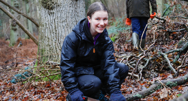 A Young Forester cutting a tree branch at Middle Spernal