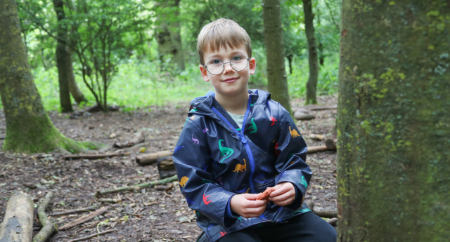 A child having fun in the woodland at Gorcott Hill